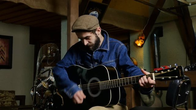 Bearded man playing on guitar. Bearded musician. Young musician playing on guitar in pub.