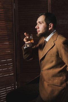 Man in suit tastes expensive cognac