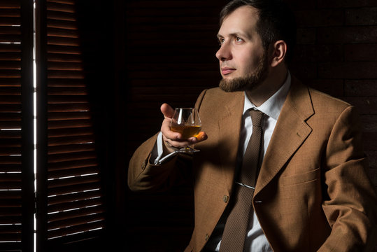 Man in suit tastes expensive cognac