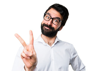 Handsome man with glasses making victory gesture