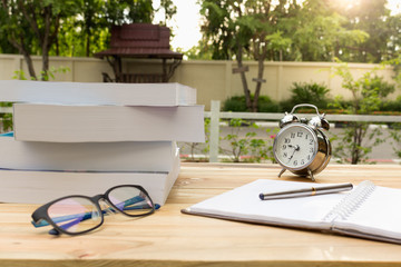 Obraz na płótnie Canvas Desk on the balcony with a notepad book watches glasses and pen on the table