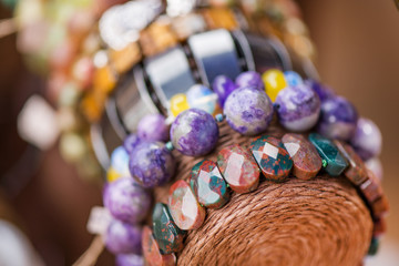 Gemstone bracelets and necklaces in a row. Jewelry made of blue agate crystal, mountain quartz, red...