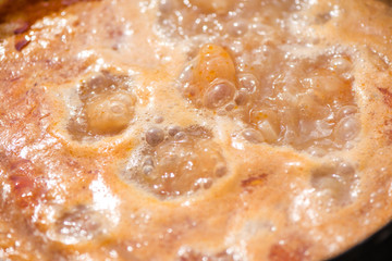 Boiling, hot goulash soup with meat, paprika, potatoes, onion, carrots is the traditional dish of Hungarian cuisine. Meat stew being prepared in crock pot on open fire. Picnic at the weekend in nature