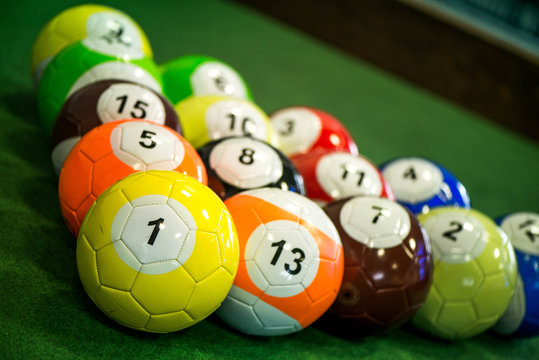 Shot of foot pool balls standing on green table. Foot Pool is the hybrid combination of pool and soccer. Big billiard balls.