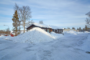 Crossing two streets covered with snow with a big snowdrift in the middle