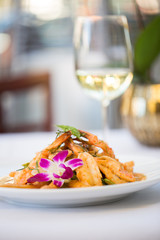 Thai Chicken Satay with Sauce Diner on a White Plate with an Orchid with Wine