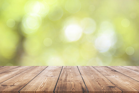 Wooden plank with natural green bokeh background