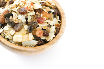 Muesli and dried fruit in wooden bowl isolated on white background. Copyspace