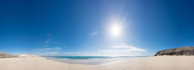 Panorama of the sandy sea beach with the sun