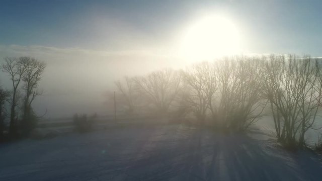 Aerial dolly shot amazing foggy winter morning sunrise over farm fields
