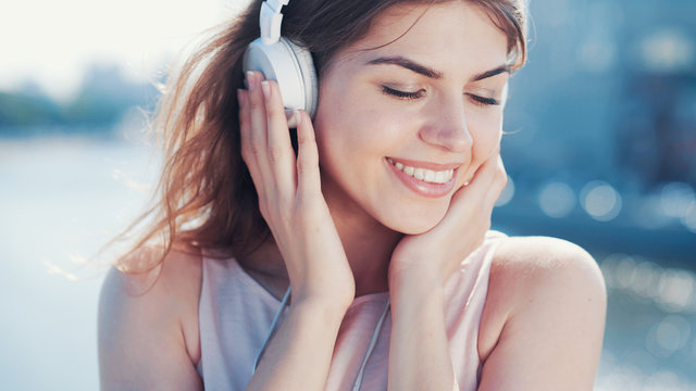 Smiling girl listen to music outdoors