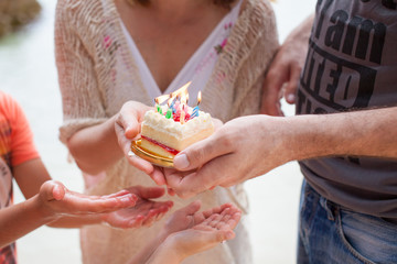 Family birthday party. The whole family is holding a cake.