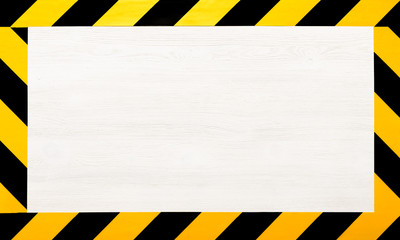Under construction concept background. Warning tape frame on white wooden surface background with...