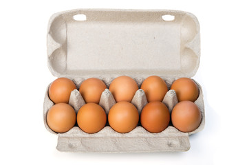 Dozen chicken eggs in a cardboard container. Isolated on white background