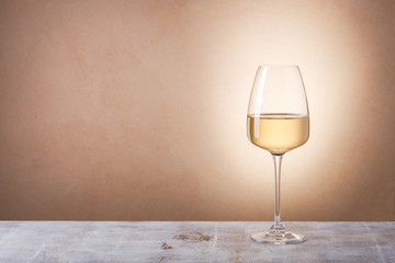 Glass with white wine on table