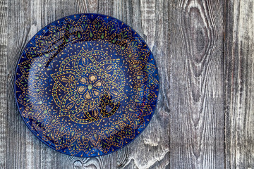 Top view blue hand-painted plate on wooden surface