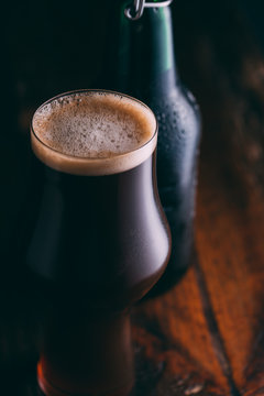 Stout beer in glass abd bottle on dark background