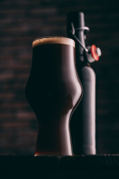 Stout beer in glass abd bottle on dark background