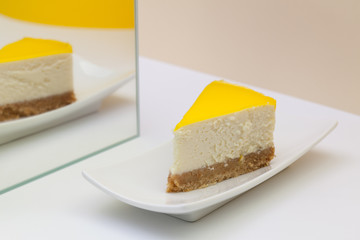 One piece of lemon cheesecake on a white  plate.