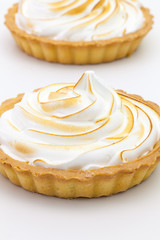 Two lemon tartalets on the white desk