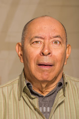 Obraz premium Portrait of a happy mature man doing funny faces and posing for camera in a blurred background