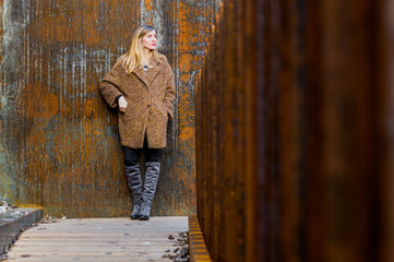 Beautiful blonde by the rusty wall