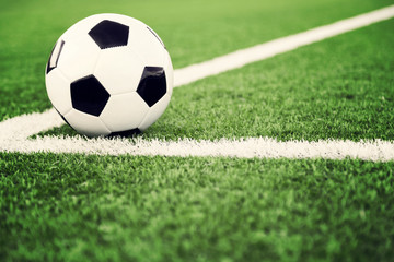 Naklejka na ściany i meble Traditional soccer ball on grass field