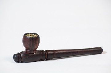 Smoking pipe stuffed with hemp on a white background. Hash pipe.