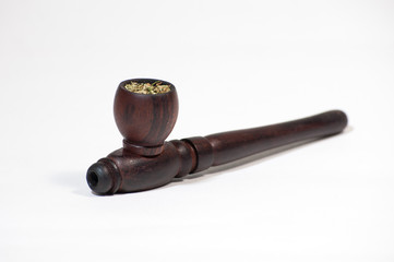 Smoking pipe stuffed with hemp on a white background. Hash pipe.