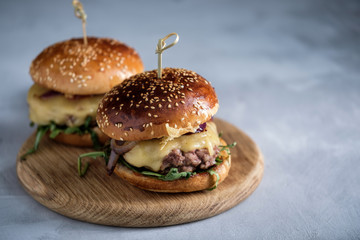 Homemade juicy burger with beef, cheese and caramelized onions. Street food, fast food. Copyspace.