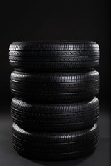 Fototapeta na wymiar Stack of car tires on black background