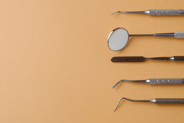 Dental mirror, dipstick, spatula on orange background, top view