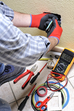 Electrician technician at work with safety equipment on a residential electrical system