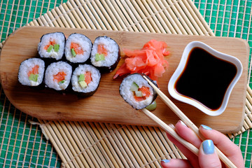 Girl holding chopsticks ready to roll, top view