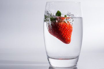 Erdbeere im Wasser - Spritzendes Wasser durch fallende Frucht in das Glas