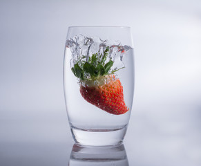 Fallende erdbeere in das Wasser