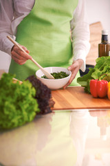 Close Up of human hands cooking vegetable salad in kitchen on the glass table with reflection. Healthy meal, and vegetarian food concept