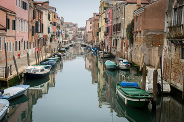 Fototapeta na wymiar Venise, Italy - 03 10 2018: Canal de Venise, avec ponts, bateaux et façades colorées