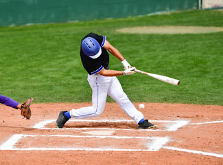 Baseball players swinging the bat at a fastball from the pitcher