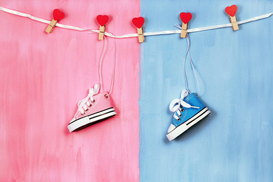 Baby sneakers on pink and blue background, baby shower party concept