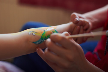 Artist is making butterfly picture on kids birhtday