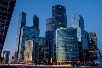 Obraz na płótnie Canvas Skyscrapers in Moscow, a frozen river, a bridge, an evening landscape 