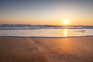 Obraz premium Majestic ocean sunrise with a breaking wave.