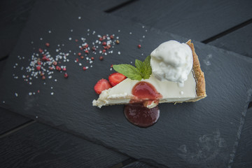 Cheesecake with ice cream on a dark background