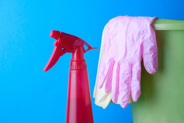 Red spray on a blue background, a bucket, pink gloves, cleaning - Powered by Adobe