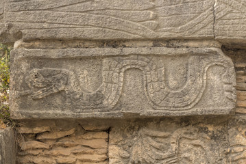 Stone wall detail in Mayan ruins Chichen Itza. Bas relief carved Snake showing its tongue. 