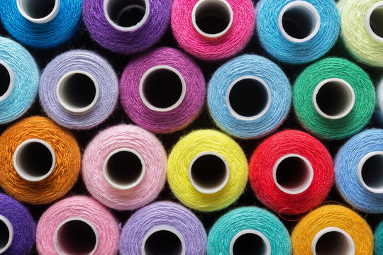 sewing thread in different colors pink blue green red