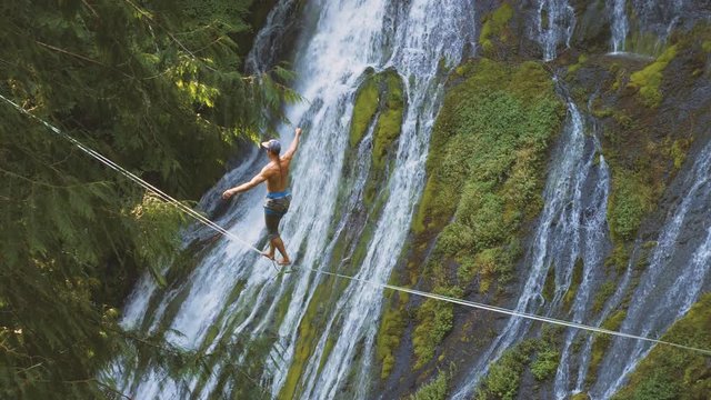 Fit Man Highlining Over A Waterfall In Oregon