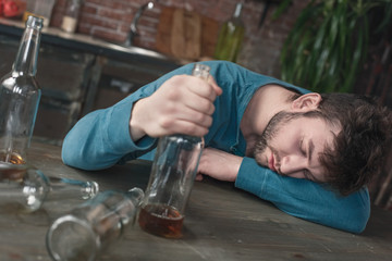 Young man alcoholic social problems concept sleeping drunk