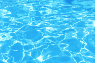 Naklejka na ściany i meble Background of clean blue rippled water in a hotel swimming pool